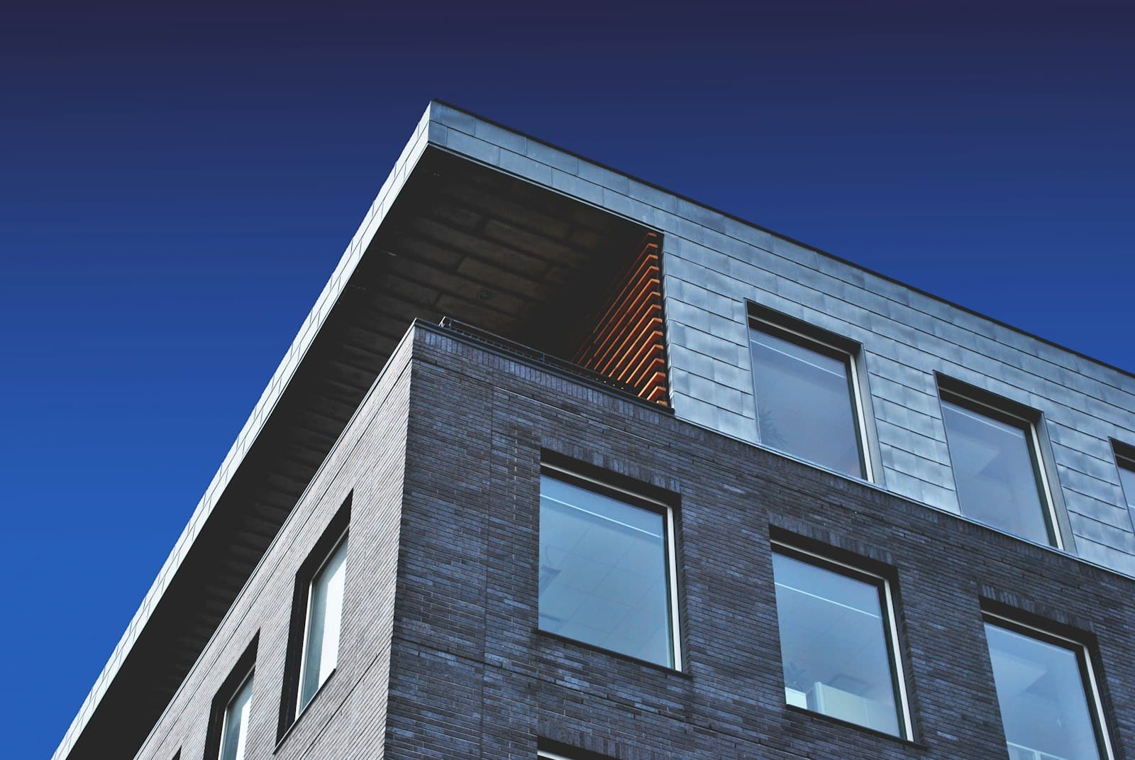Corner of a brick residential building against a clear sky