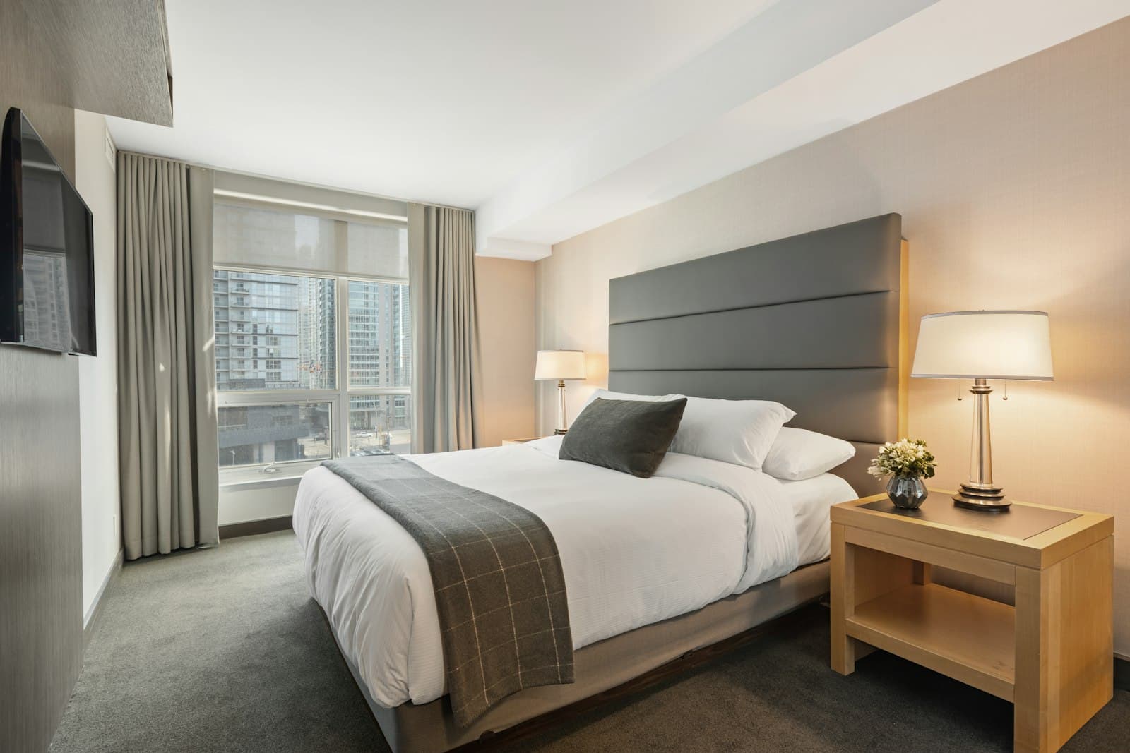 Neatly made double bedroom with bedside lamps
